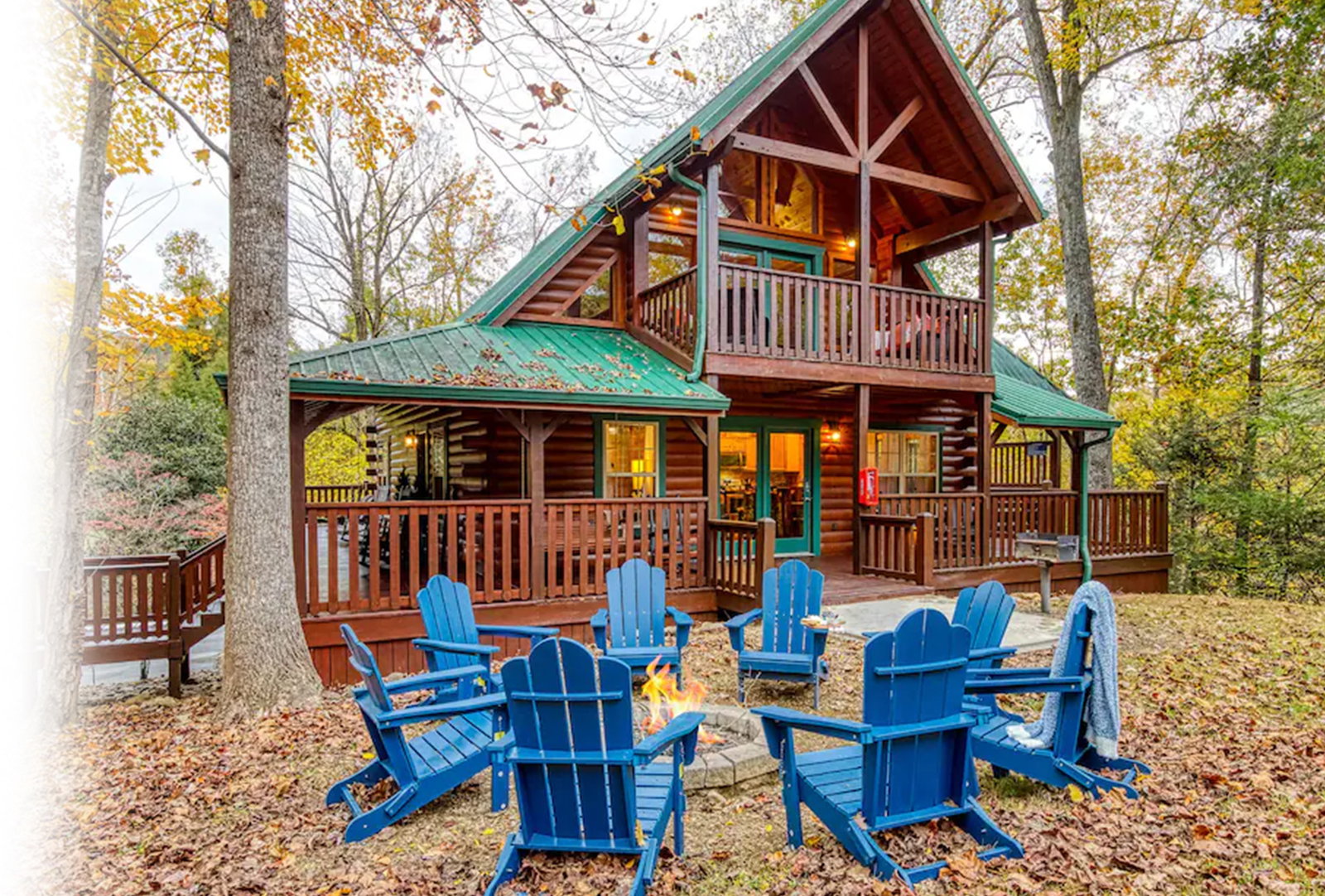 Rustic log cabin with decks, fire pit, and autumn forest setting.