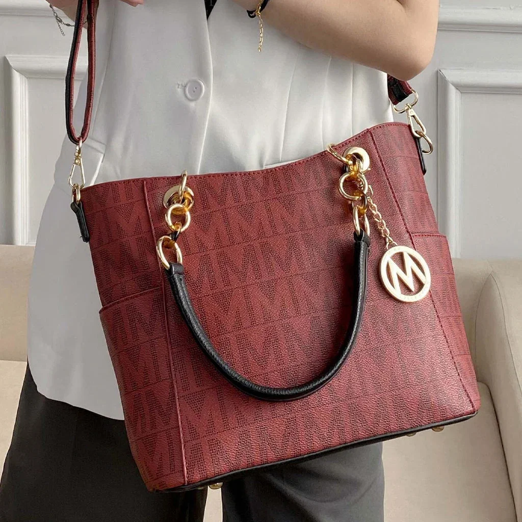 Woman holding a burgundy textured tote bag with gold chain handles and MKF Collection charm by Luxury Bags by MKF Collection