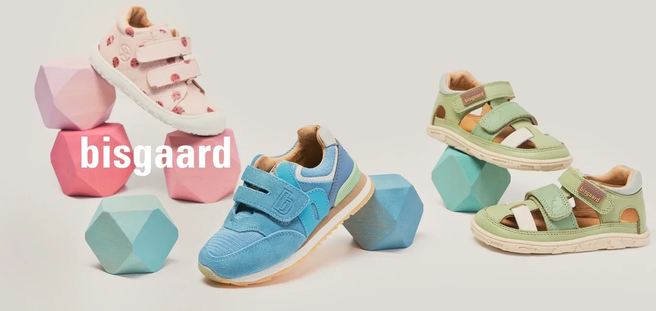 Trois paires de chaussures pour enfants en rose, bleu et vert, présentées avec des blocs géométriques pastel assortis sur un fond uni.