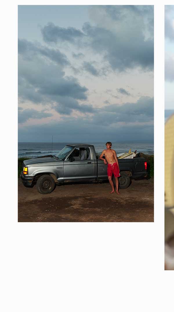 Man leaning against truck on the cliff edge in Hawaii