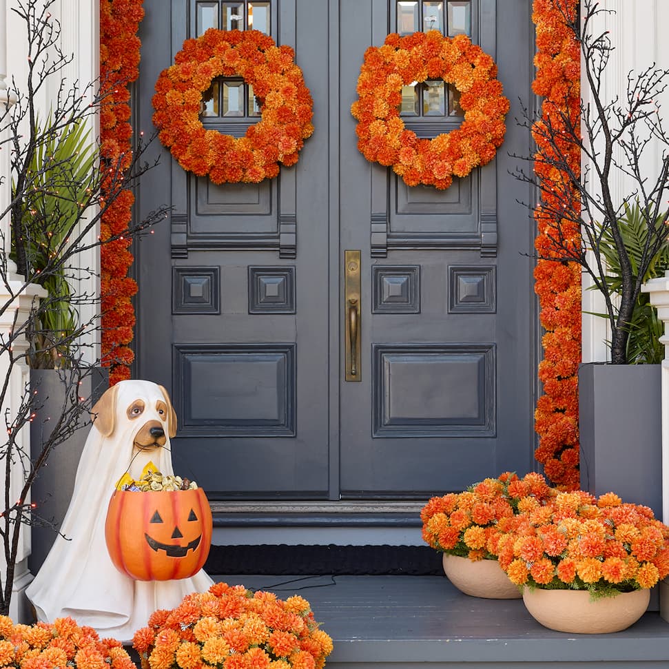 A front porch adorned with Halloween decorations like ghost dog and marigold flowers