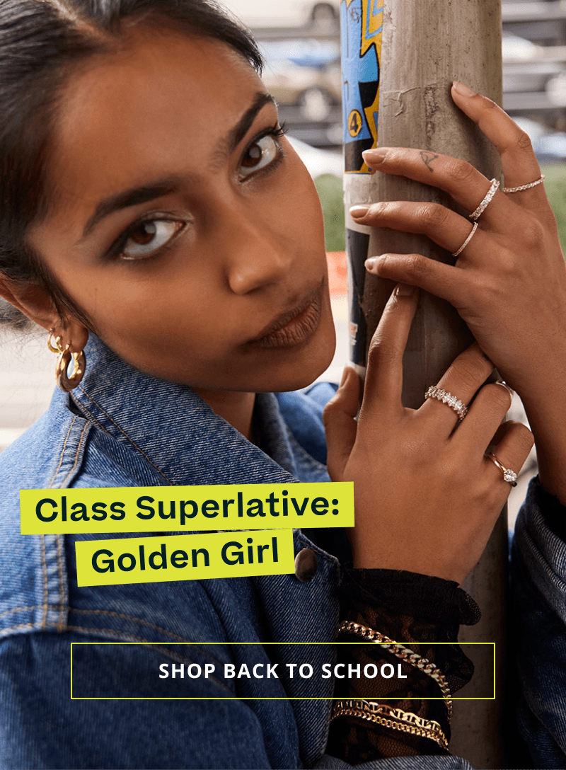 Model with assortment of gold chain bracelets, diamond ring stack & gold hoops. Golden Girl. Click here to shop back to school