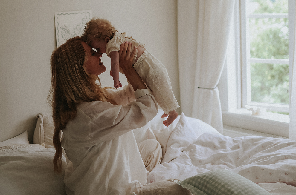 woman holding up child