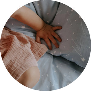 child's hand on bedding