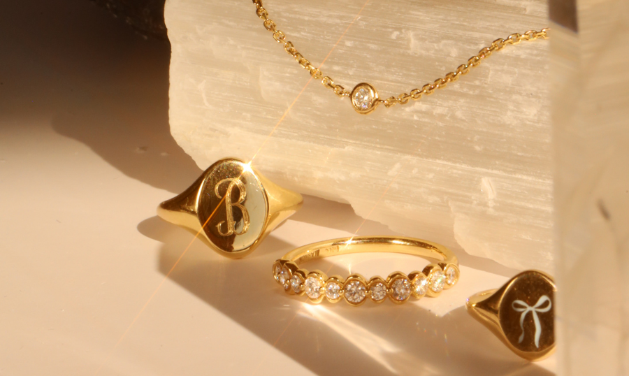 flat lay of yellow gold jewelry against a neutral background