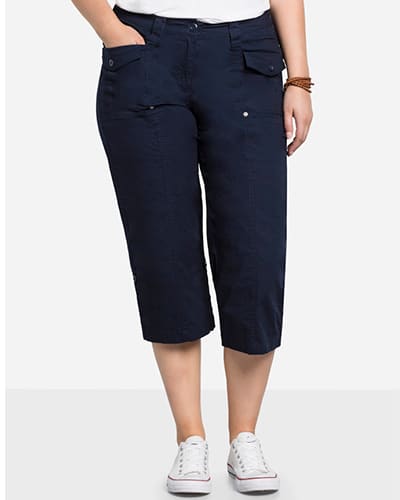 Ein Model trägt eine marine blaue 3/4-Hose mit Krempelfunktion am Beinabschluss