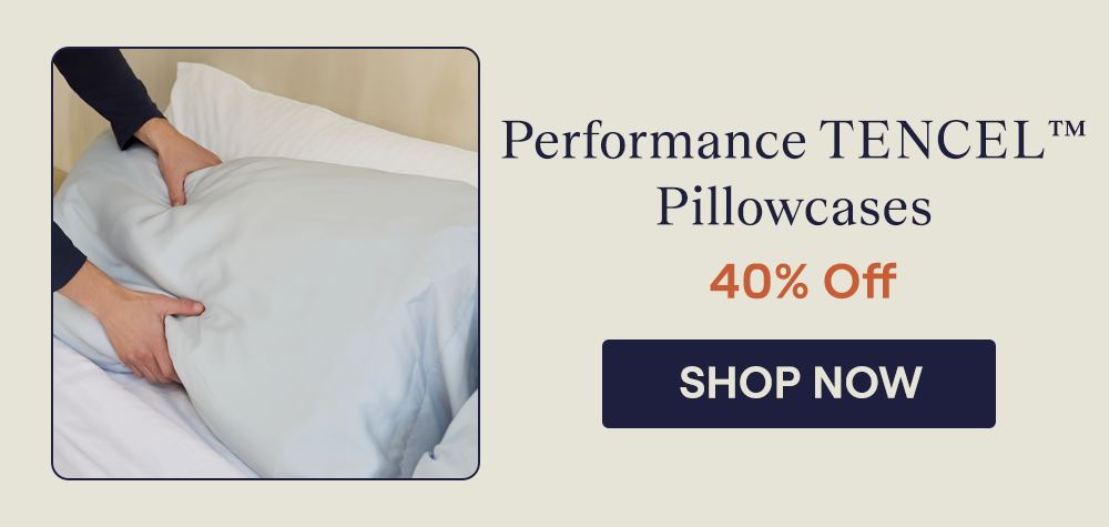 Man placing a pillow with the Alice Performance TENCEL™ pillowcases on a bed