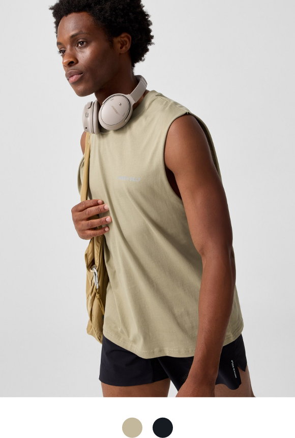 A young man is wearing a khaki green muscle T-shirt from INNER SELF, at $50.00.