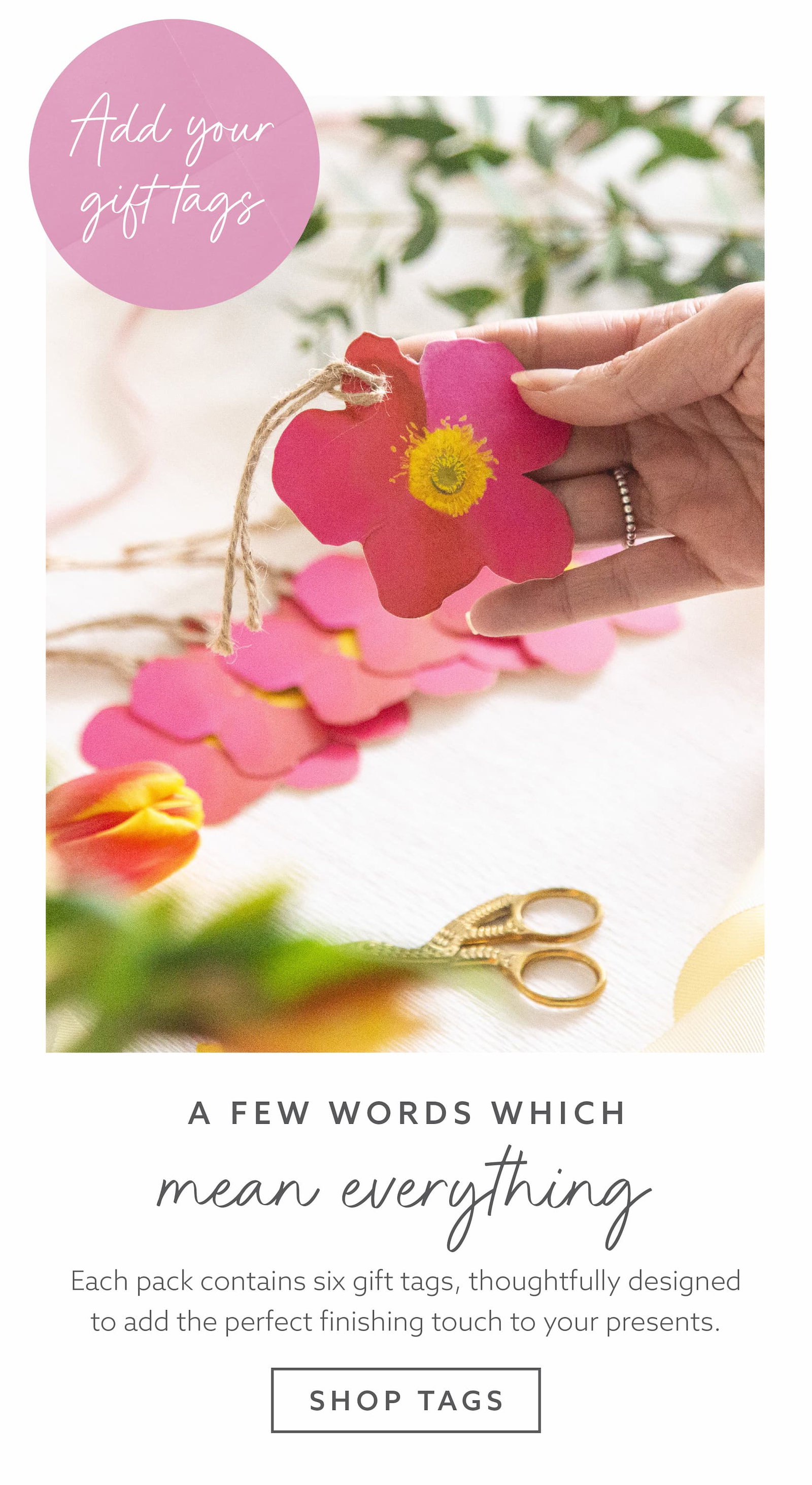 Hand holding a floral-shaped Whistlefish gift tag, showcasing beautifully designed gift tags for adding a personal finishing touch to presents.