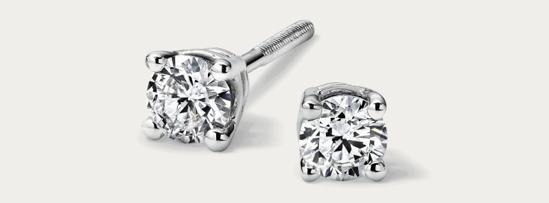 White gold round diamond stud earrings in four-prong setting.