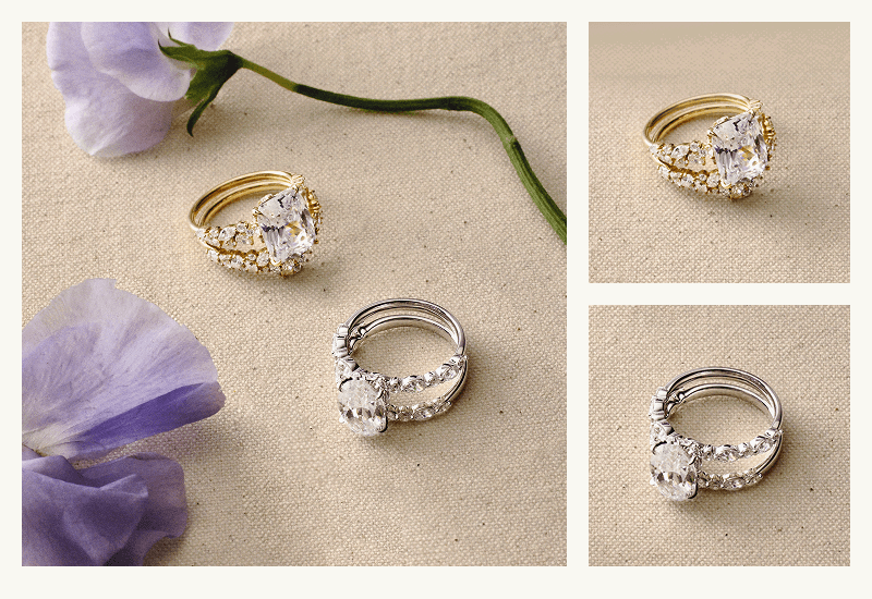 Diamond ring stacks, in yellow gold with radiant stone & white gold with oval stone, arranged next to flowers.