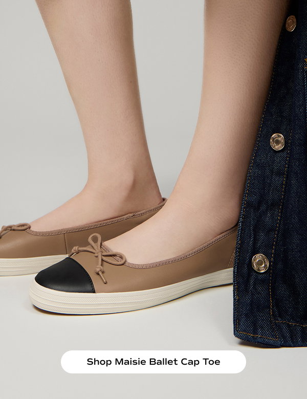 A side view of a pair of Maisie Ballet Toe Cap Leather flats in tan/black shown on foot. A dark wash jean jacket is shown on the right side of image. Shop Maisie Ballet Cap Toe.