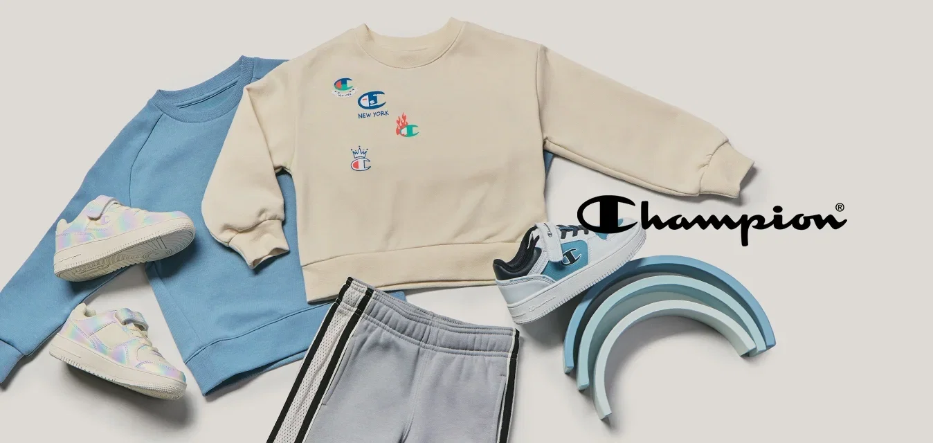 Dos sudaderas infantiles, pantalones deportivos grises, tres pares de zapatillas deportivas y una pila de juguetes de madera con tonos azules en forma de arcoíris sobre un fondo beige.