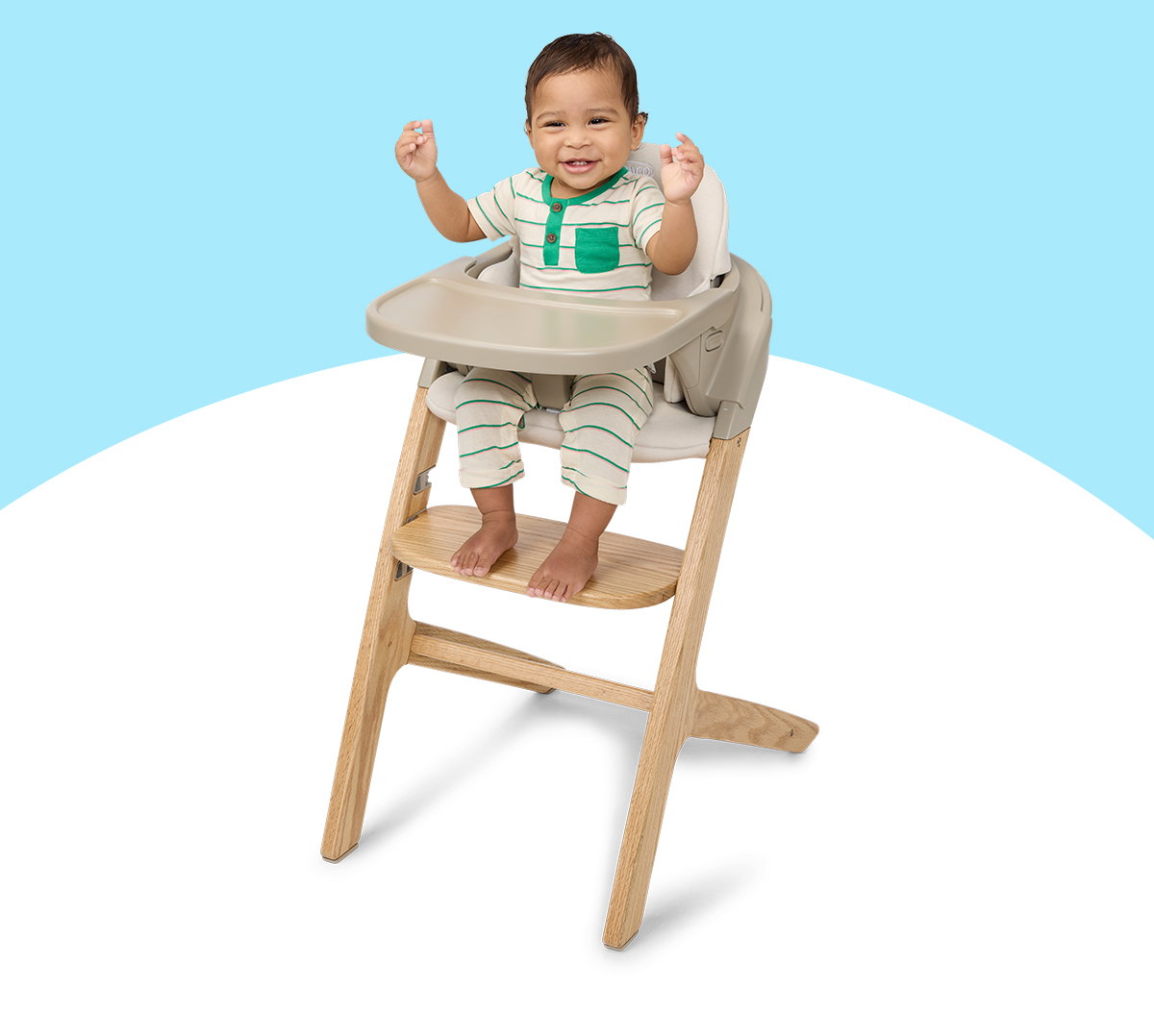 Smiling toddler seated at the tray of the Graco Close2Baby 2-in-1 Highchair.