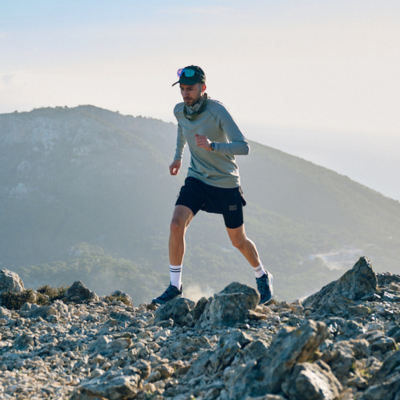 Trail runner running up a rocky mountain path