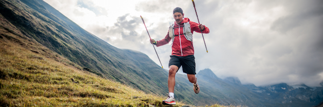 A bearded man running up a mountain