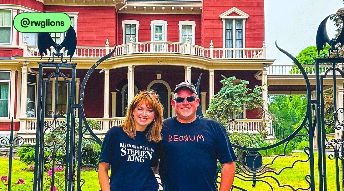 Image description: Two people standing in front of a red house with Stephen King-themed shirts, photo taken by @rwglions