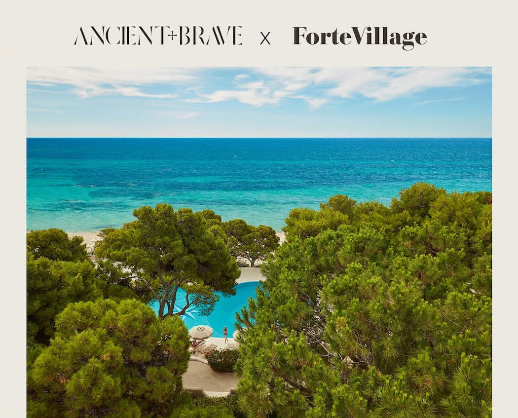 View through pine trees of a pool and beach at Forte Village on the Mediterranean coast with the caption 'Win a mini-break at Forte Village'.