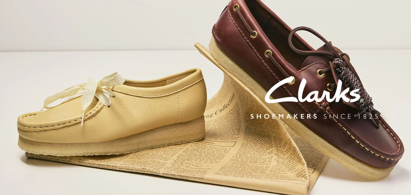 Mocassin beige et chaussure bateau marron foncé à lacets exposés sur un livre, sur fond blanc uni.