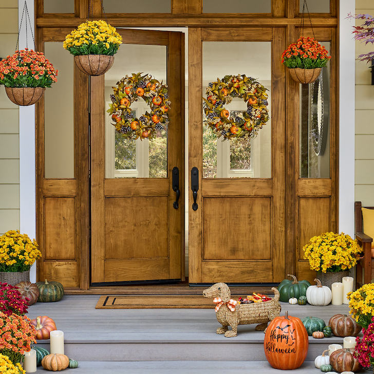 A front porch covered with fall wreaths and other greenery