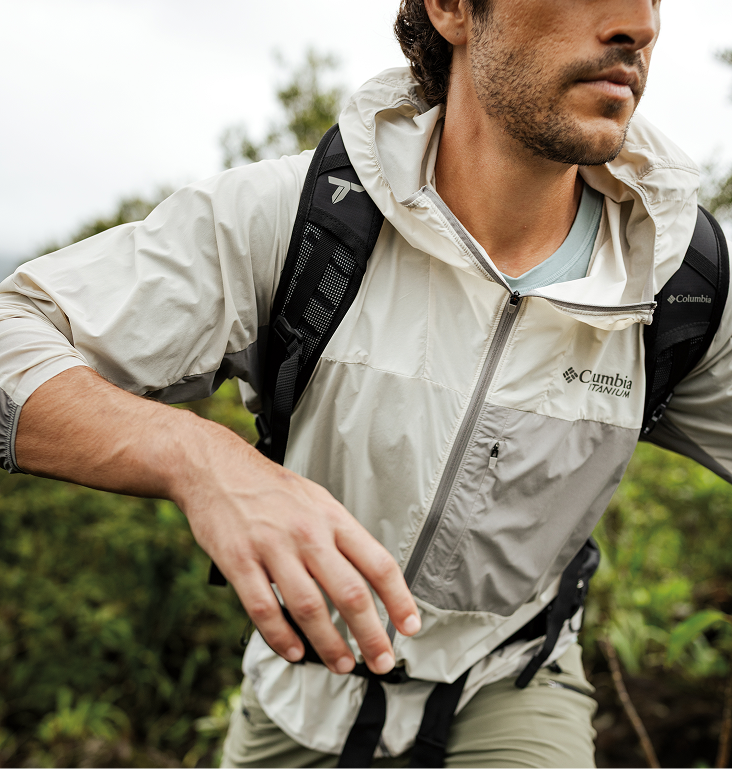 A man backpacking while wearing a Columbia Titanium windbreaker.