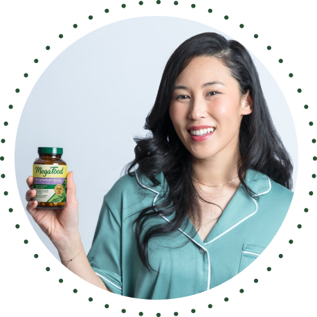 Woman in blue pajamas holding MegaFood Magnesium