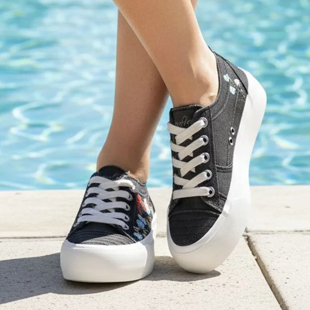 Two black and white platform sneakers with colorful accents displayed poolside at a sunny resort location.