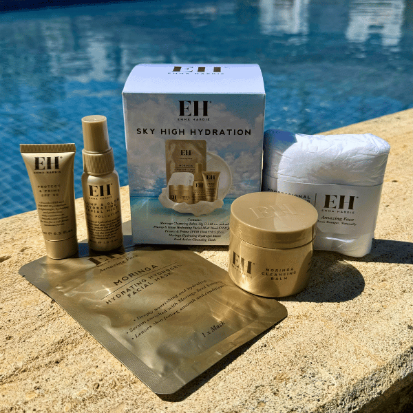 Emma Hardie Sky High Hydration travel skincare set displayed beside a swimming pool.