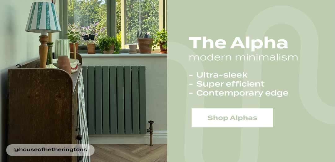 The Aloha modern vertical radiator in a muted green finish beneath a window with houseplants, with text promoting ultra-sleek design, energy efficiency, and contemporary style.