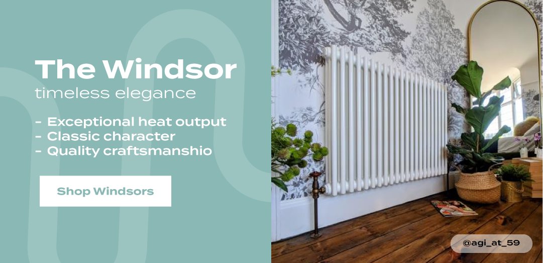 The Windsor traditional white column radiator installed beneath an arched mirror in a bright room, with text highlighting exceptional heat output, classic character, and quality craftsmanship.