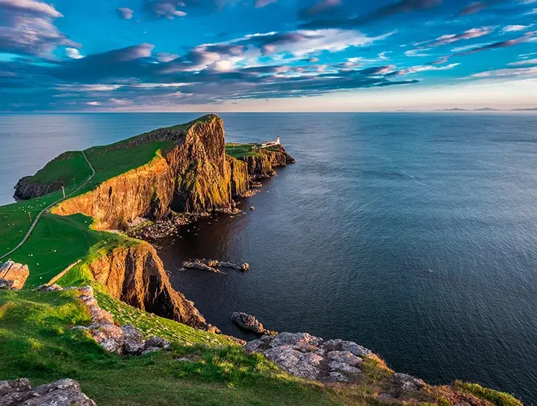 El faro de Neist Point en la Isla de Skye, sobre acantilados dorados por la luz del atardecer