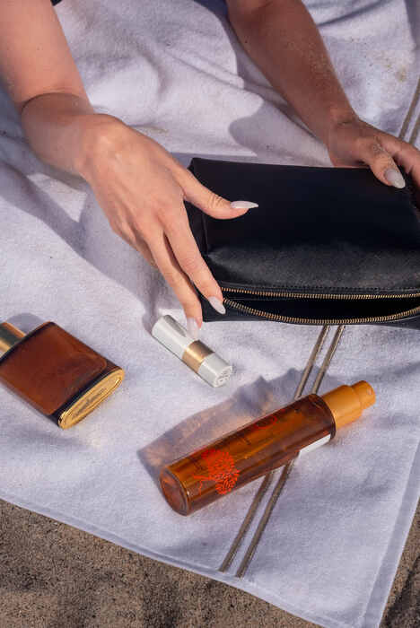 Beauty essentials arranged on the beach