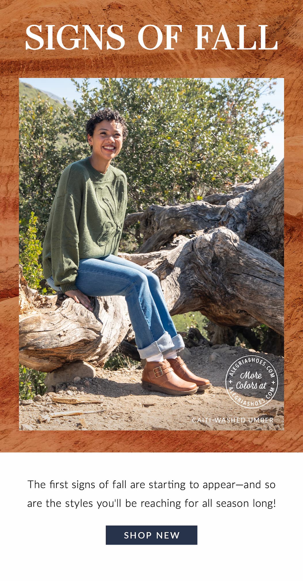 Signs of Fall banner featuring a smiling woman sitting outdoors on a large fallen tree trunk wearing a green knit sweater, cuffed jeans, and brown leather Alegria Caiti boots in Washed Umber.
