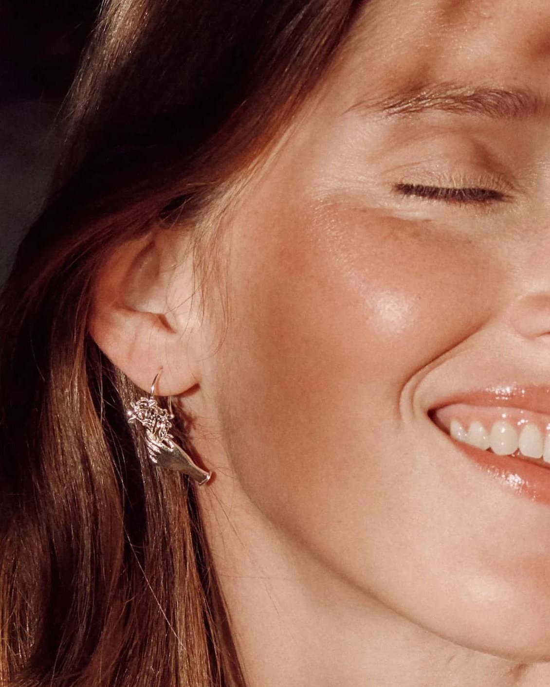 Close-up of model wearing handcrafted silver necklaces and earrings.