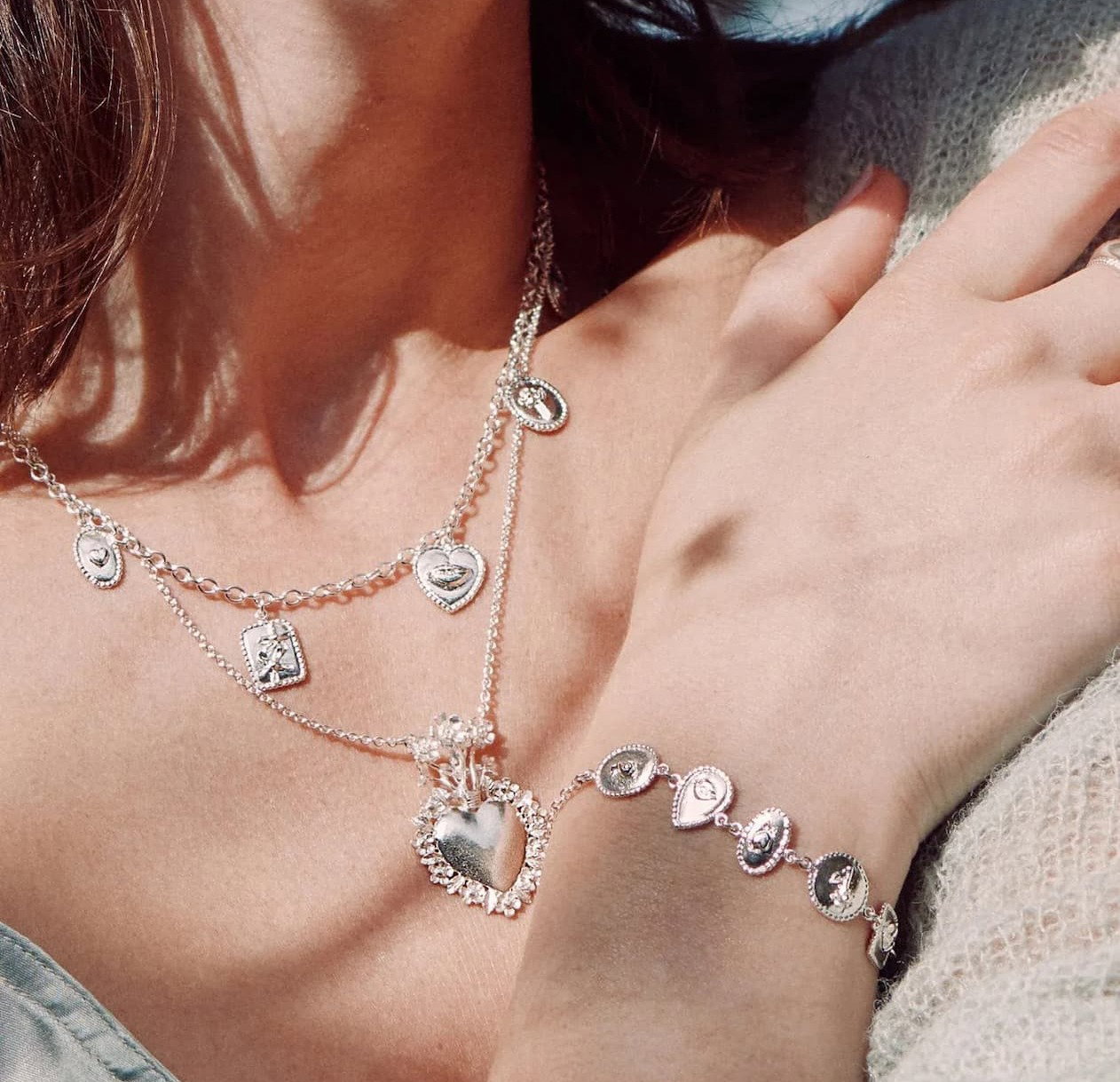 Model wearing layered handcrafted silver jewellery from the Summer in Silver collection.