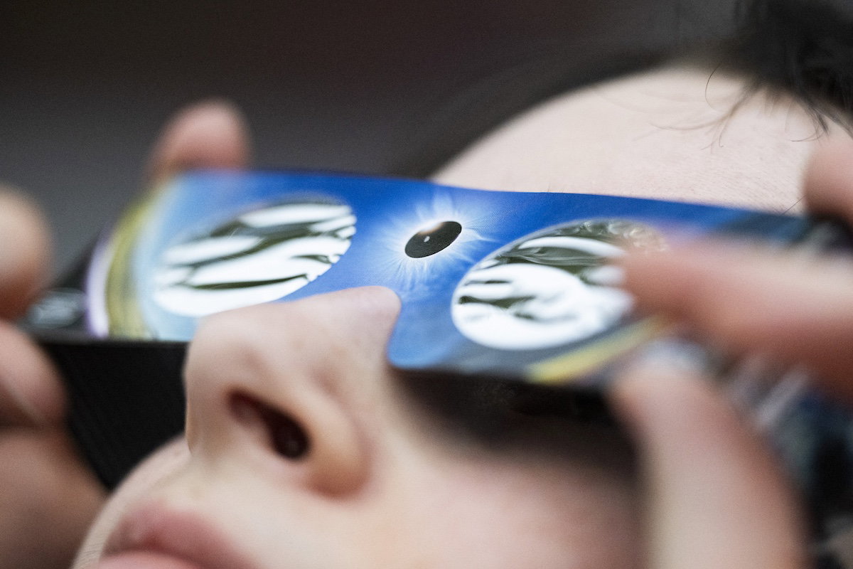 Enfant portant des lunettes de protection pour observer une éclipse solaire