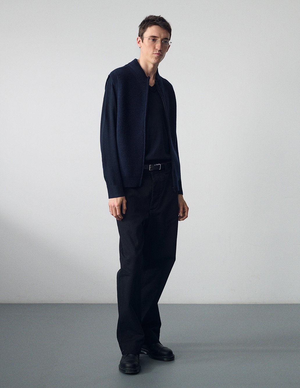 Navy zip gilet and black trousers.