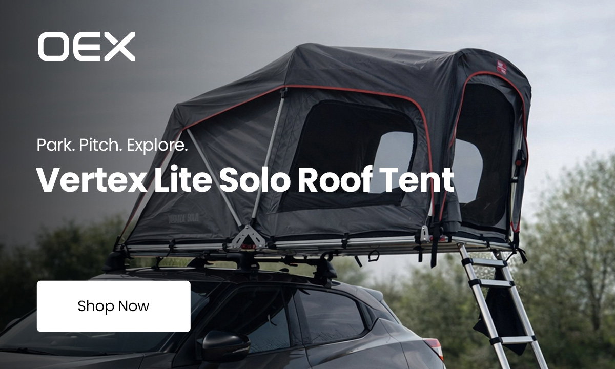 OEX Vertex Lite Solo roof tent mounted on top of a parked vehicle with an access ladder extended to the ground. Overlaid text reads “Park. Pitch. Explore.”, “Vertex Lite Solo Roof Tent” and “Shop Now”.