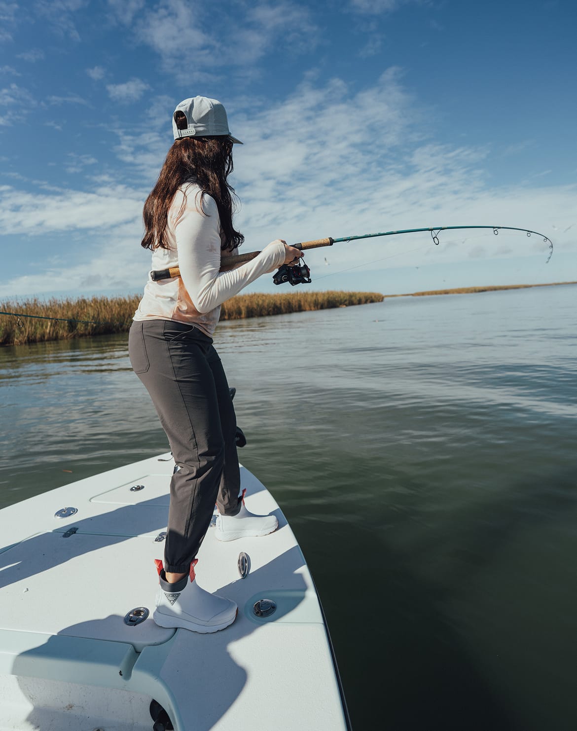 A woman fishing off a boat