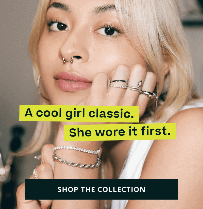 Model in horseshoe septum nose ring & silver rings & bracelets. Cool girl classic. Click here to shop the collection
