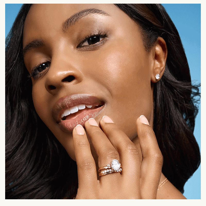 Model with large oval-cut diamond ring & eternity bands.