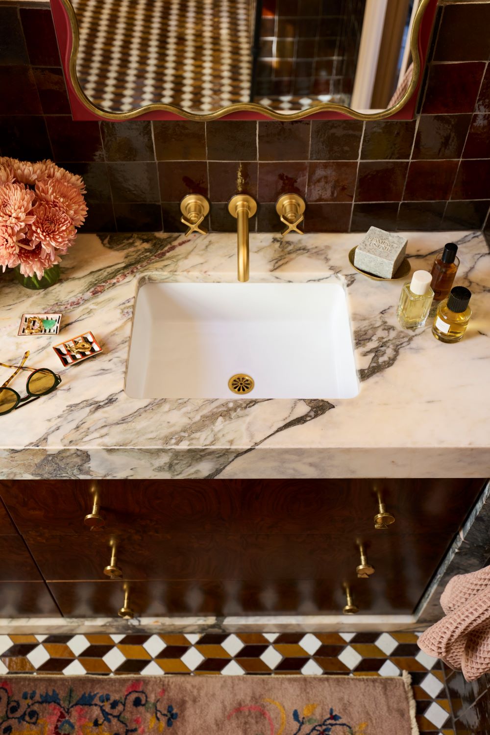 A warm, design-forward bathroom with marble vanity featuring the KOHLER Castia faucet.