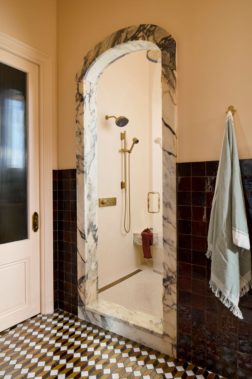 Arched doorway leading to a walk-in shower with the Anthem shower control.