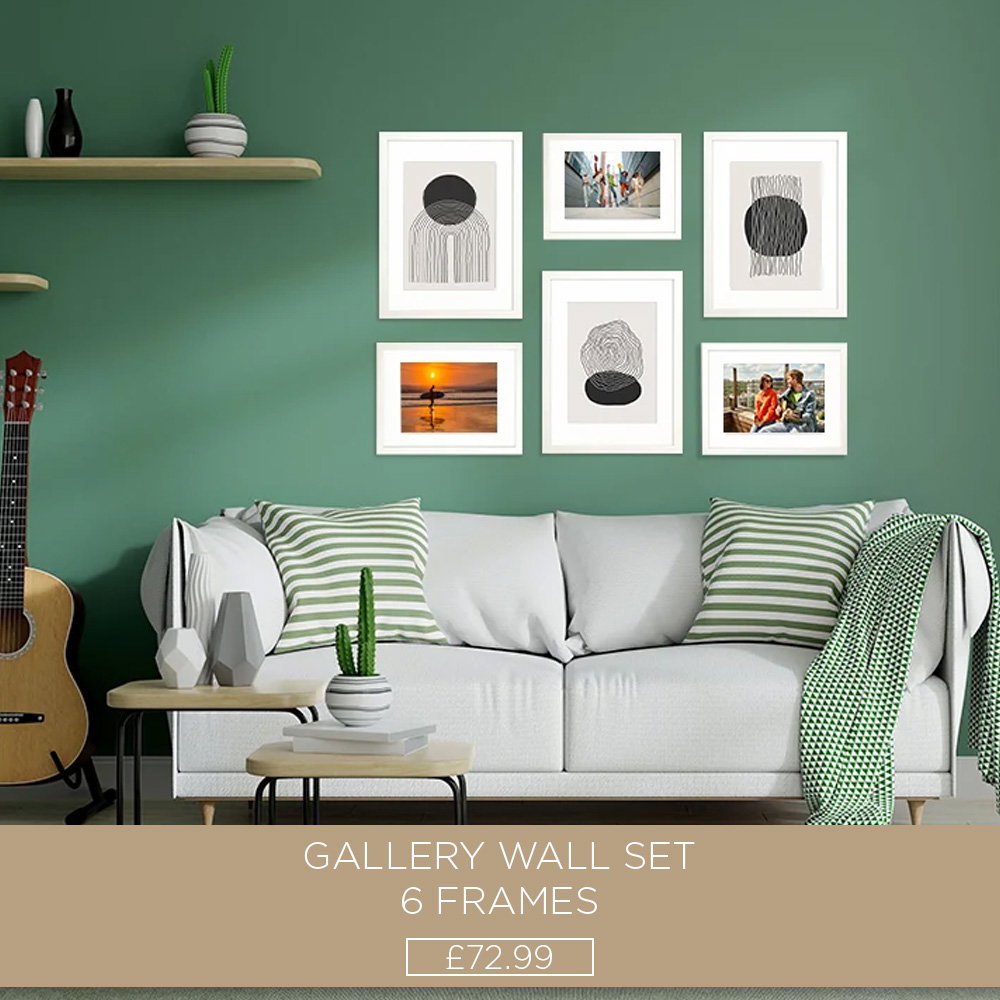 Six-piece white gallery wall frame set with artwork and photos displayed above a sofa against a green feature wall.