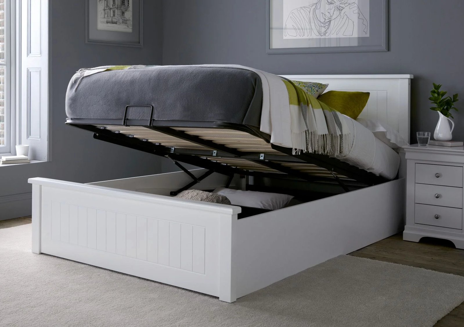 A white, wooden ottoman bed showcasing underneath storage.