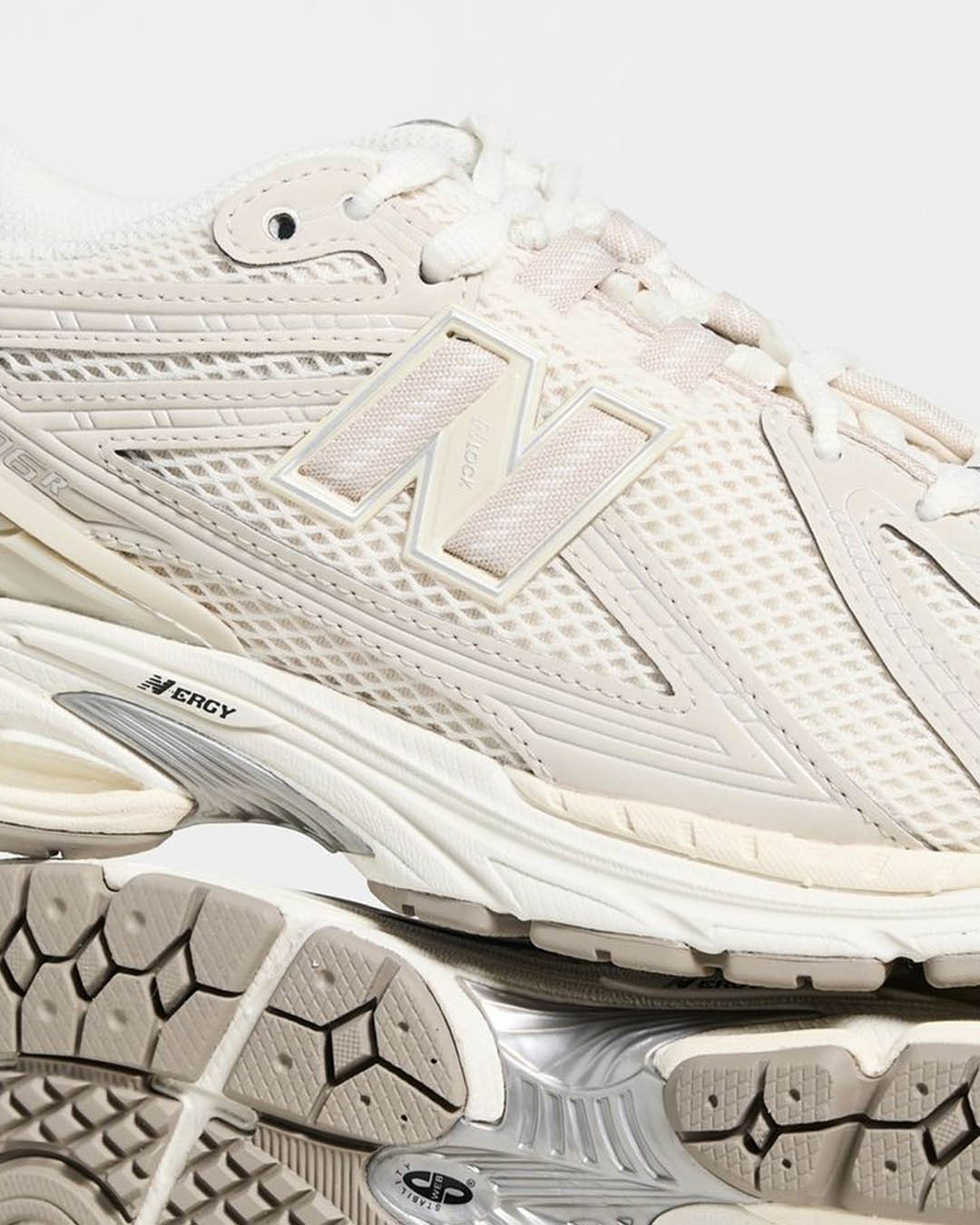 Close-up of cream New Balance running trainer, mesh upper, 'N' logo and cushioned ERGY sole tread detail