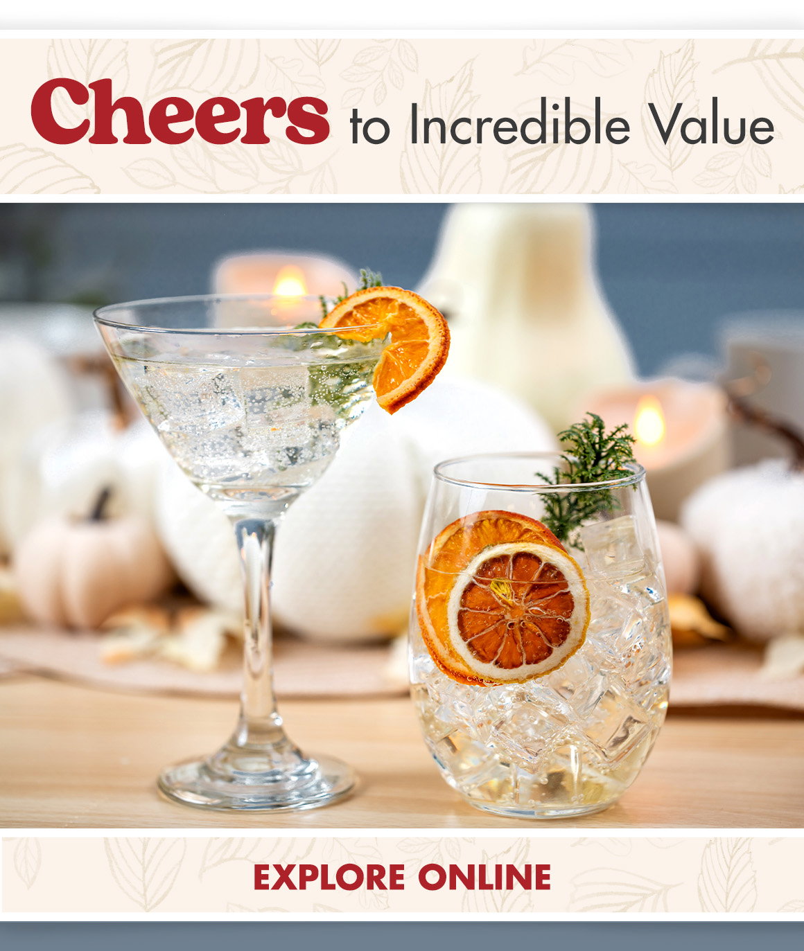 Cheers to Incredible Value. Image of a martini glass and a stemless wine glass garnished with orange and fall herbs at a dinner place setting with fall table decorations.