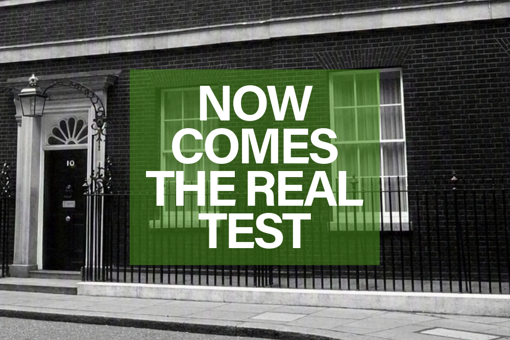 a black and white image showing the exterior of ten Downing Street; overlaid is the text “Now comes the real test.”