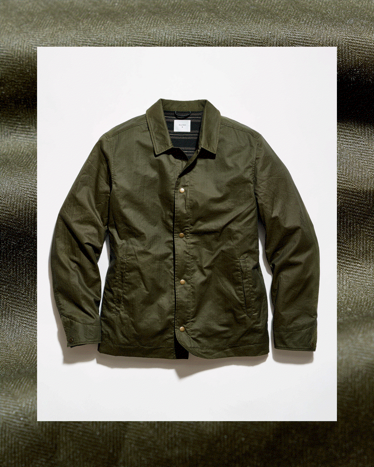 Gif shows the outside of the waxed jacket, as well as the reverse featuring a striped lining.