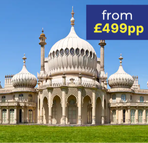 A grand building with ornate domes and arches set against a clear blue sky.